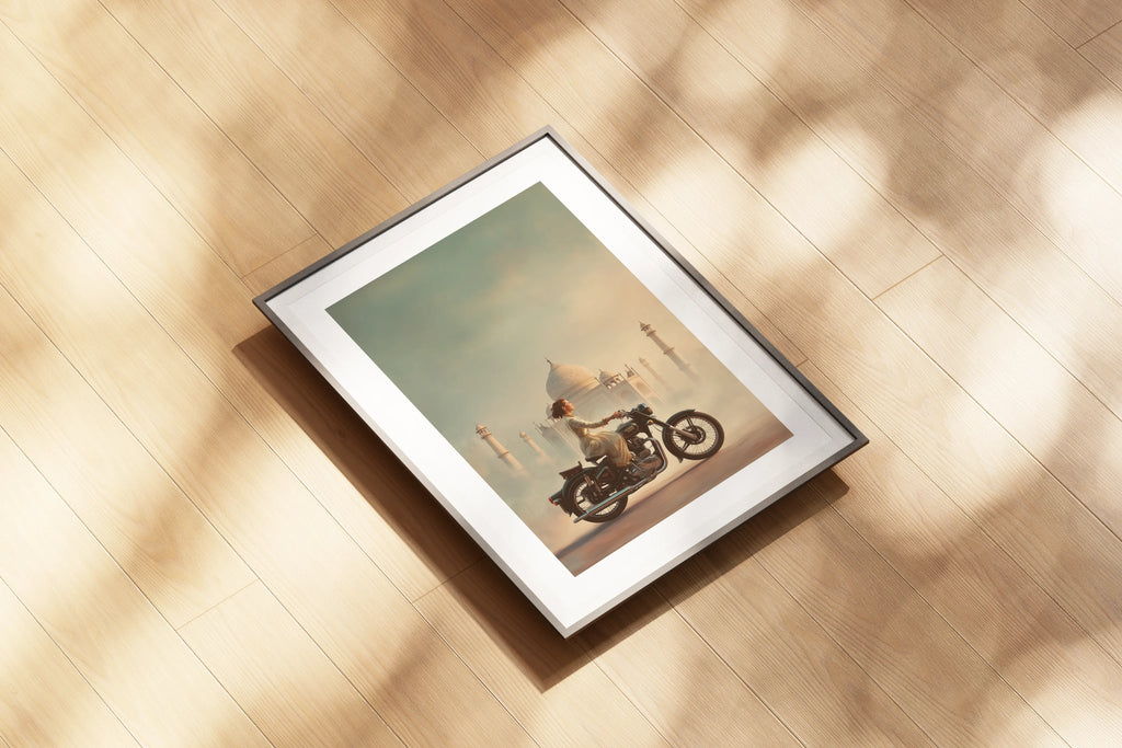 Affiche Royal Enfield aérographe posée au sol, motarde et Taj Mahal, reflets chrome et tons chauds.