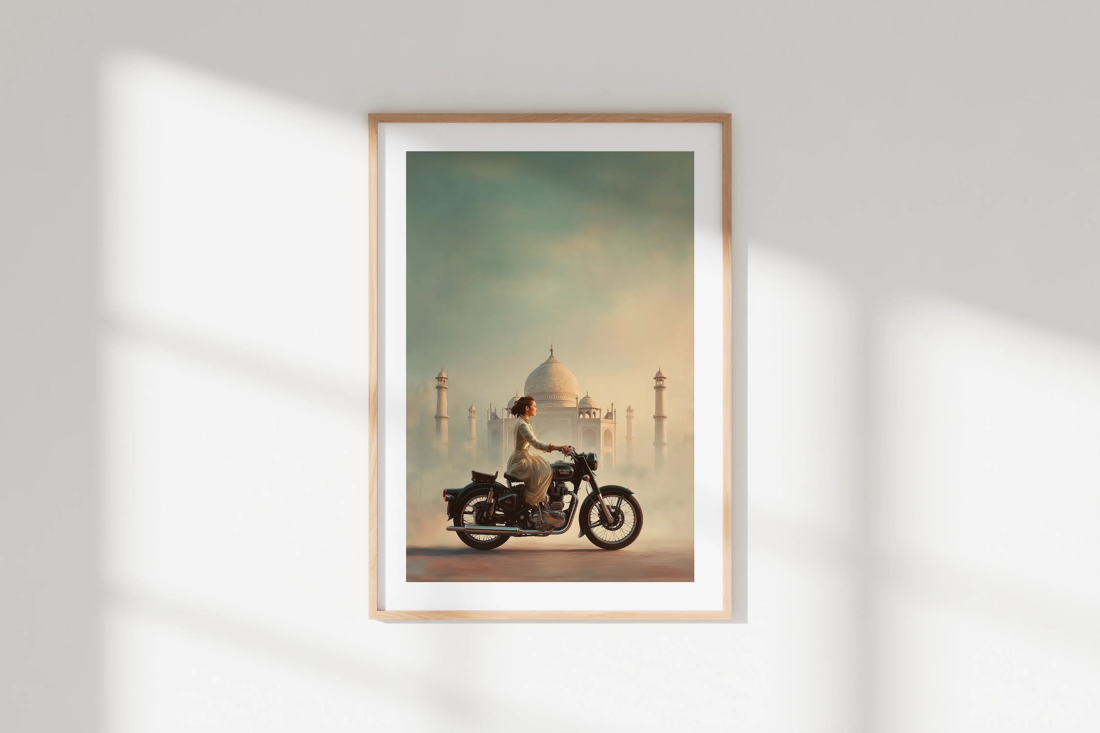 Affiche Royal Enfield aérographe, motarde face au Taj Mahal, encadrée sur mur blanc, déco intérieure.